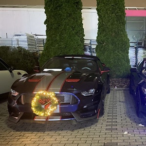Sogenannte Muscle-Cars mit Weihnachtsdekoration sind auf einem Parkplatz in Ramstein-Miesenbach abgestellt.