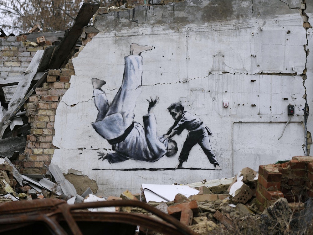 Sonntag, 13. November: Mehrmals schon ist Banksy in Krisengebieten aktiv geworden. Nun hat er mehrere Werke in der Ukraine hinterlassen. An diesem beschädigten Gebäude in der Nähe von Kiew ist ein Kind zu sehen, das einen Erwachsenen beim Kampfsport umwirft.