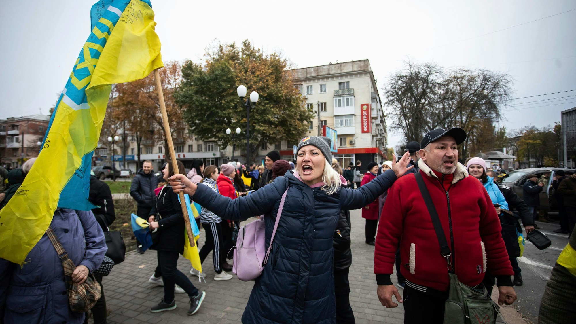 Ukrainer versammeln sich in der Innenstadt von Cherson, um die Rückeroberung ihrer Stadt in Cherson, Ukraine, zu feiern. Viele haben ukrainische Fahnen dabei.