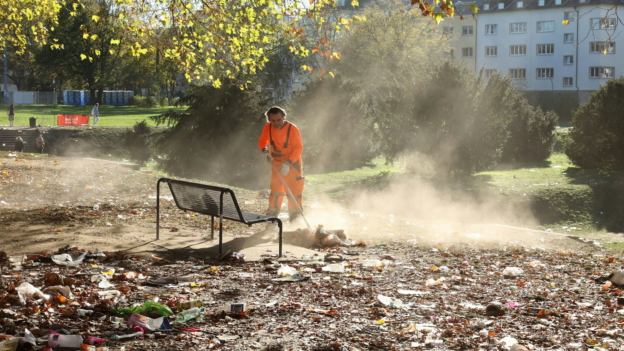 Ein Mitarbeiter der AWB entfernt Müll von den Kölner Uniwiesen