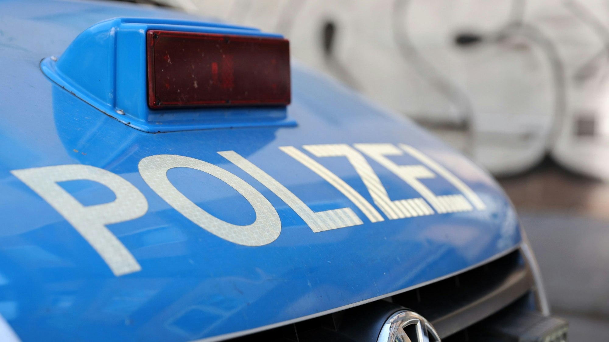 Frontansicht auf die Haube eines Polizeiautos mit der Aufschrift „Polizei“ (Symbolbild)