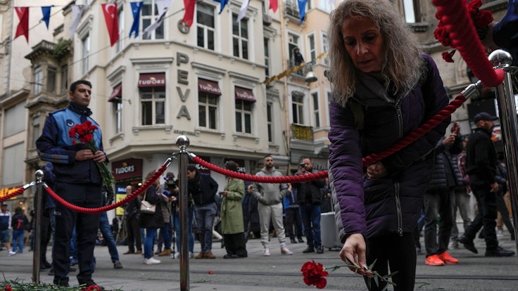 Eine Frau legt Blumen nieder am Ort der Explosion auf der Fußgängerzone Istiklal. Bei dem Anschlag am Sonntag 13.11.2022 auf der belebten Einkaufsstraße waren mehrere Menschen getötet worden und viele wurden verletzt.