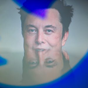 Der neue Twitter-Besitzer Elon Musk blickt durch das Twitter-Logo mit dem markanten blauen Vogel. (Symbolbild)