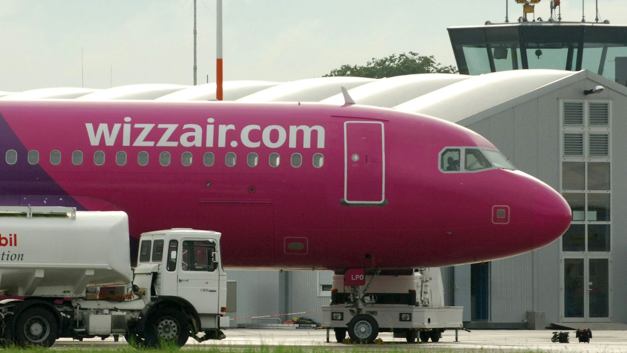 Ein Flugzeug der ungarischen Fluglinie Wizzair steht auf dem dem Flughafen in Lübeck. Zu sehen ist das markante Magenta auf einem Airbus, in dem die Flugzeuge der ungarischen Airline gestrichen sind. (Symbolbild)