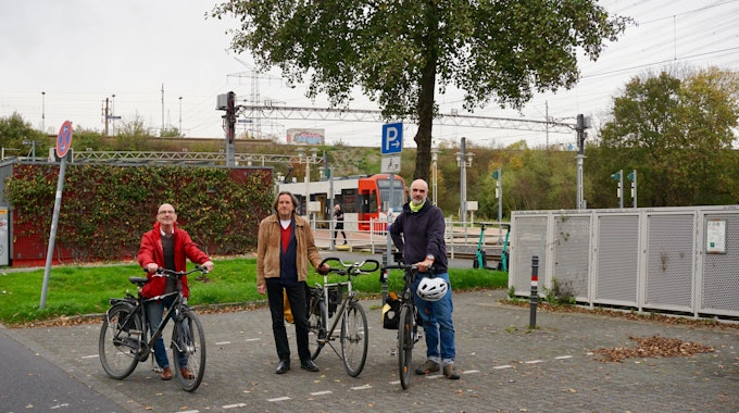 Thomas Roth, Roland Schüler und Axel Fell an der Stelle des Park-and-Ride-Platzes, wo der Kölner Bike-Tower bereits stehen sollte. Im Hintergrund ist eine KVB-Straßenbahn zu sehen.