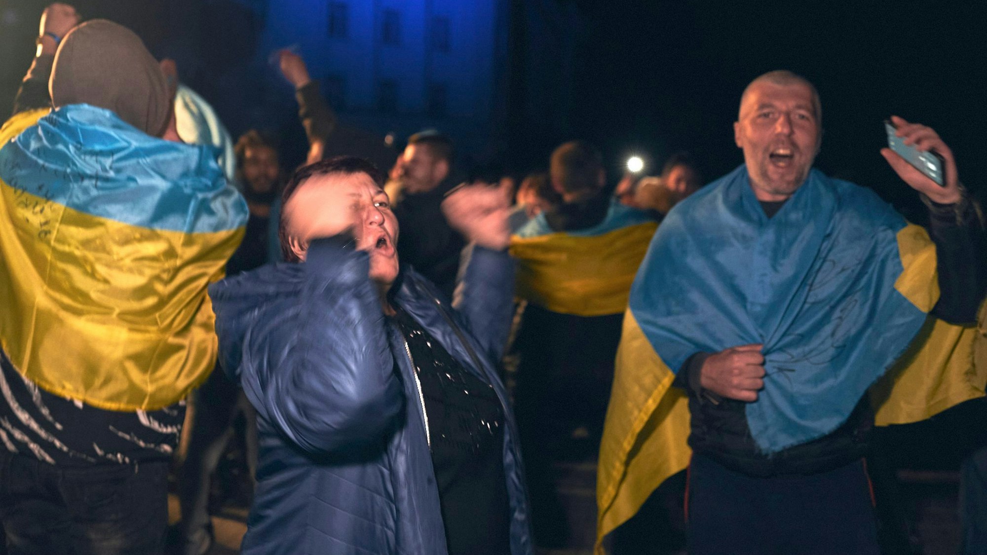 Ukrainer versammeln sich nachts in der Innenstadt von Cherson, um die Rückeroberung der Stadt durch die Ukraine zu feiern.