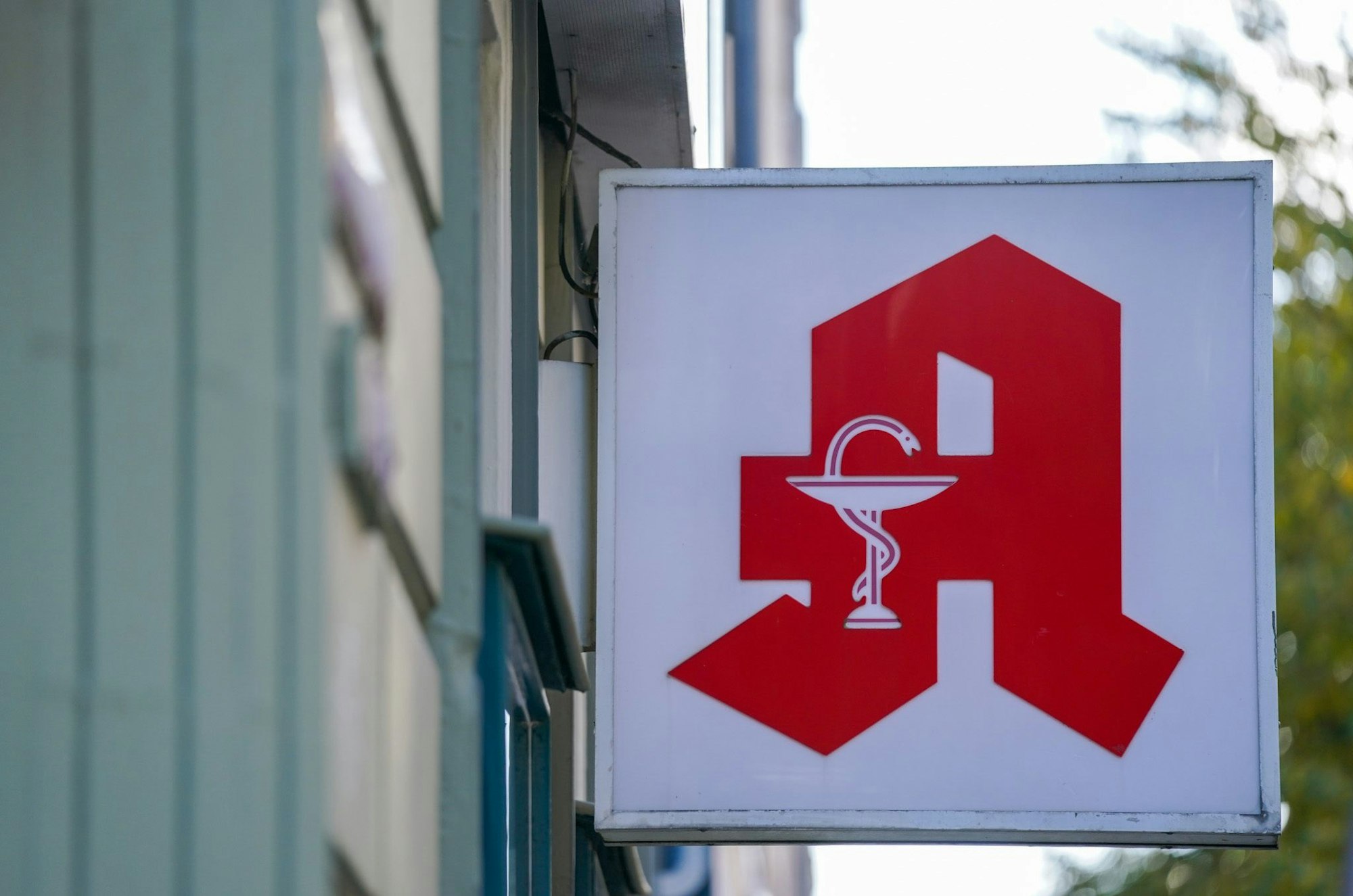Symbolfoto. Ein Apotheken-Logo hängt an der Eingangsfassade einer Apotheke im Stadtteil St. Pauli.