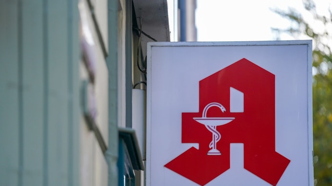 Symbolfoto. Ein Apotheken-Logo hängt an der Eingangsfassade einer Apotheke im Stadtteil St. Pauli.