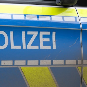 Auf der Türe eines Polizeiautos ist der Schriftzug „Polizei“ zu lesen.