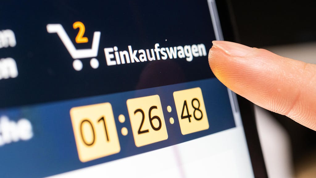 Das Symbolfoto zeigt eine Person, die auf einem Tablet auf den Amazon-Warenkorb klickt.