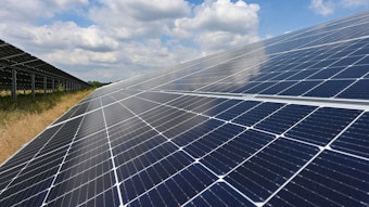 Zu sehen ist ein Solarpark mit großen schräg aufgestellten Photovoltaikflächen.