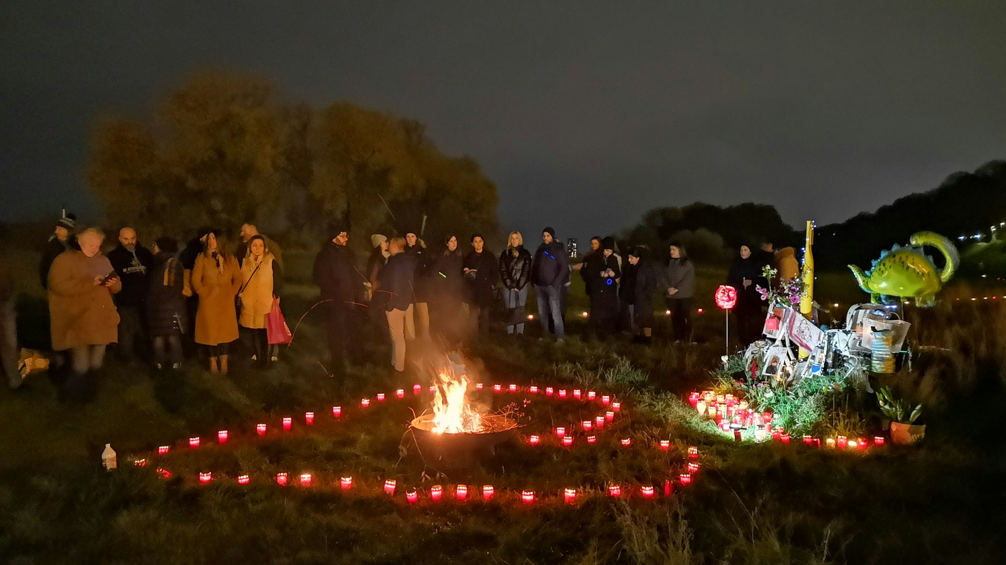 Angehörige und Freunde gedenken der vor einem Jahr getöteten Derya und Kian am Niehler Hafen mit Kerzen, die zu einem Herz geformt sind.