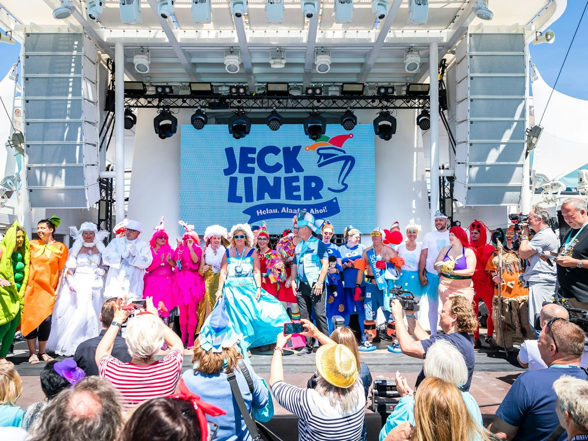 Das undatierte Foto zeigt verkleidete Karnevalistinnen und Karnevalisten, die auf und vor einer Bühne auf dem Kreuzfahrtschiff namens „Jeckliner“ feiern.