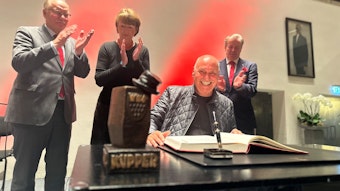 Rolly Brings wird mit dem Karl-Küpper-Preis ausgezeichnet und trägt sich ins Goldene Buch der Stadt Köln ein. Im Hintergrund applaudieren OB Henriette Reker, Festkomitee-Präsident Christoph Kuckelkorn und Bernhard Conin.