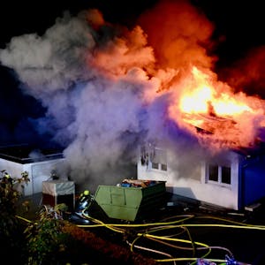 Das Dach des Einfamilienhauses steht komplett in Flammen. Die Feuerwehr bekämpft den Brand.