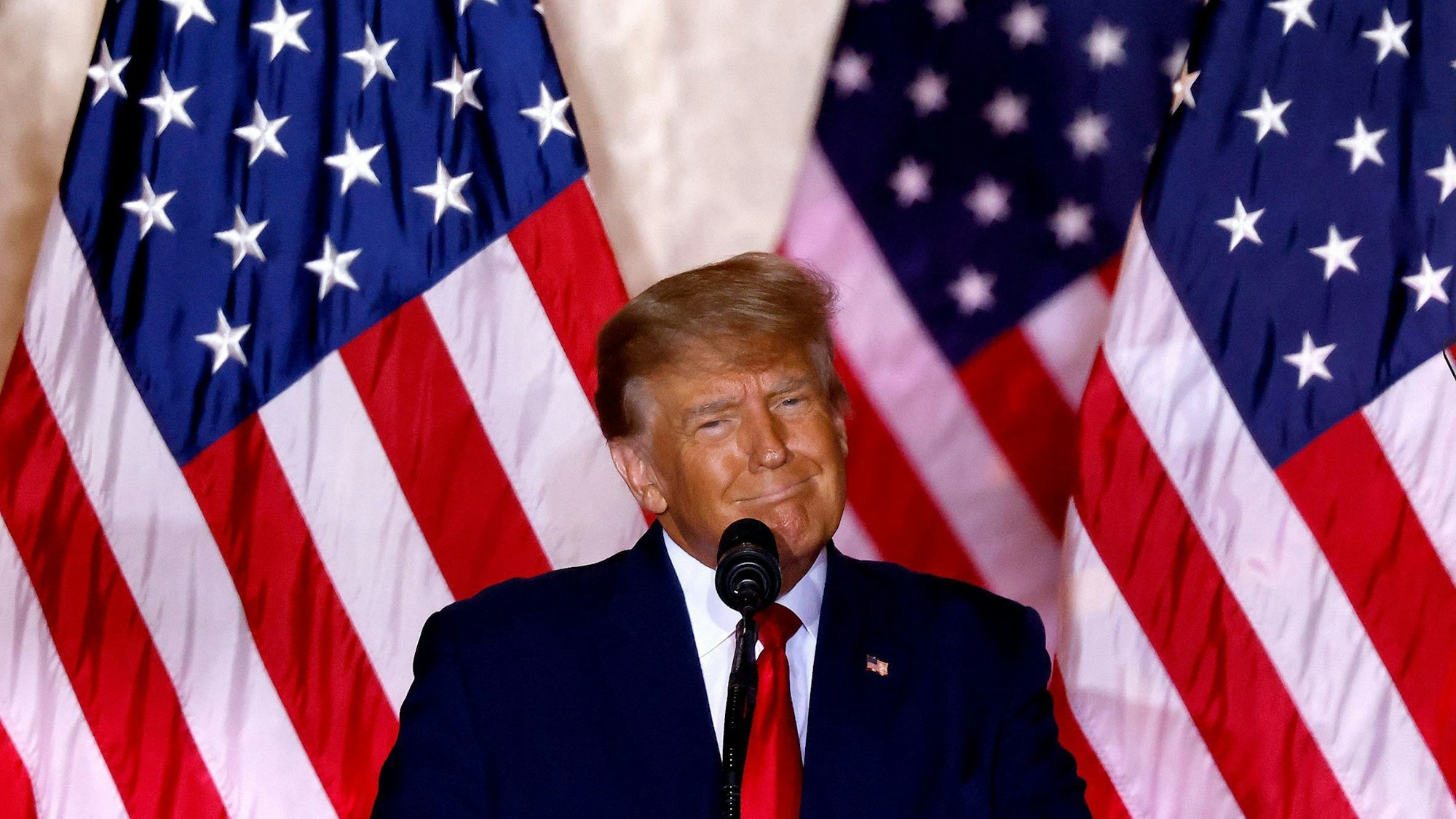 Donald Trump, ehemaliger US-Präsident, spricht vor einer amerikanischen Flagge in seinem Anwesen Mar-a-Lago über seine Kandidatur für die Präsidentenwahl 2024.