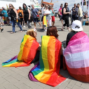 Teilnehmer haben sich mit verschiedenen Pride-Flags zur Kundgebung zum Christopher Street Day (CSD) 2020 in Rostock eingefunden. Darunter die Regenbogenfahne, die lesbische Pride Flag (Mitte) und die Trans Pride Flag (2.v.r.).