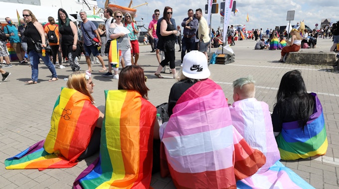 Teilnehmer haben sich mit verschiedenen Pride-Flags zur Kundgebung zum Christopher Street Day (CSD) 2020 in Rostock eingefunden. Darunter die Regenbogenfahne, die lesbische Pride Flag (Mitte) und die Trans Pride Flag (2.v.r.).&nbsp;