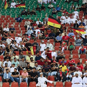 Fans sitzen beim Länderspiel der deutschen Nationalmannschaft gegen den Oman in Maskat auf der Tribüne.