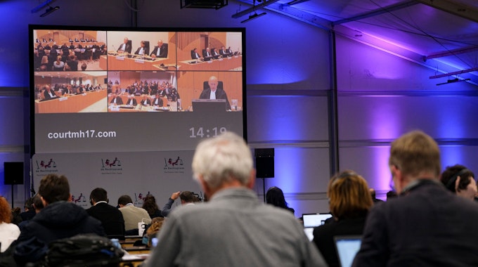 Journalisten verfolgen auf einem großen Bildschirm die Urteilsverkündung im Prozess um den Abschuss von Flug MH17.