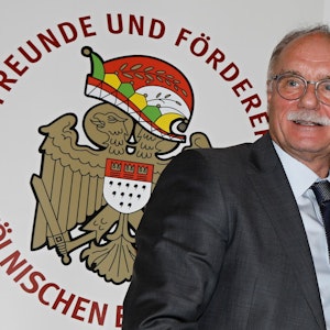 Bernhard Conin steht vor einem Plakat der Freunde und Förderer des Kölnischen Brauchtums.