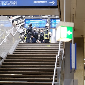Rettungskräfte stehen am Kölner Hauptbahnhof und kümmern sich um einen Verletzten.