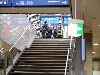 Rettungskräfte stehen am Kölner Hauptbahnhof und kümmern sich um einen Verletzten.