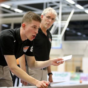 Der Rhöndorfer Cheftrainer Julius Thomas (vorne) hält einen Zettel in der Hand und instruiert seine Spieler. Co-Trainer  Martin Otto hört aufmerksam zu.