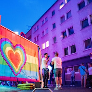 Eine Regenbogenfahne mit Herz schmückt einen Treffpunkt der Queer-Szene in Köln.