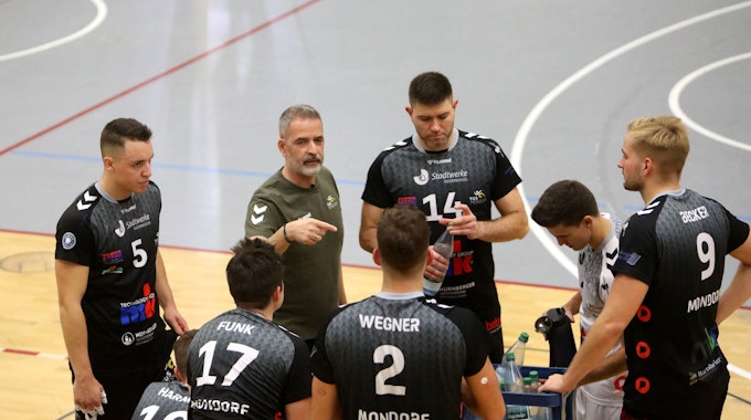 Cheftrainer Tasos Vlasakidis vom TuS Mondorf macht Ansagen und gestikuliert, seine Spieler hören gespannt zu.&nbsp;