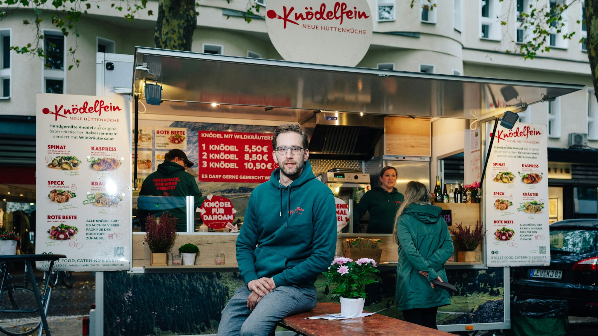 Christoph Schrader sitzt vor seinem Knödelfein-Foodtruck auf dem Kölner Rudolfplatz.