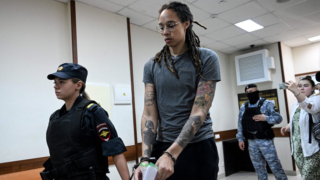 Brittney Griner wird mit Handschellen von einer russischen Beamtin aus dem Gericht abgeführt.