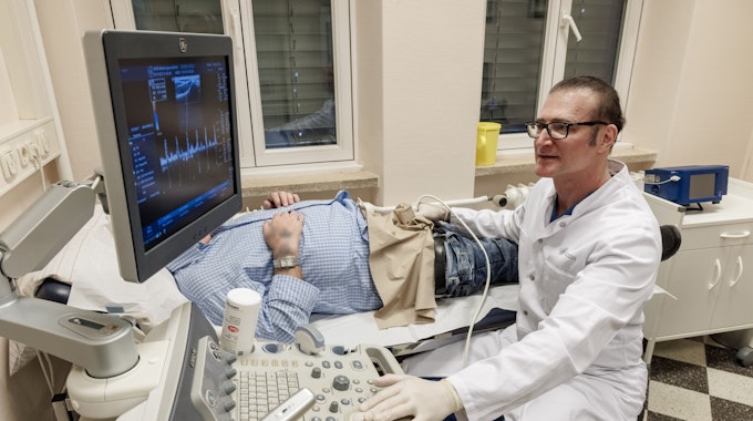Frank Sommer, Urologe, Androloge und Professor für Männergesundheit, untersucht einen Patienten mit einem Ultraschallgerät.