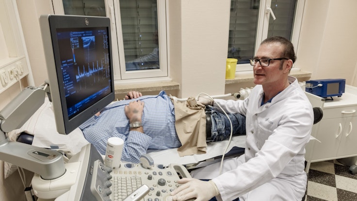Frank Sommer, Urologe, Androloge und Professor für Männergesundheit, untersucht einen Patienten mit einem Ultraschallgerät.