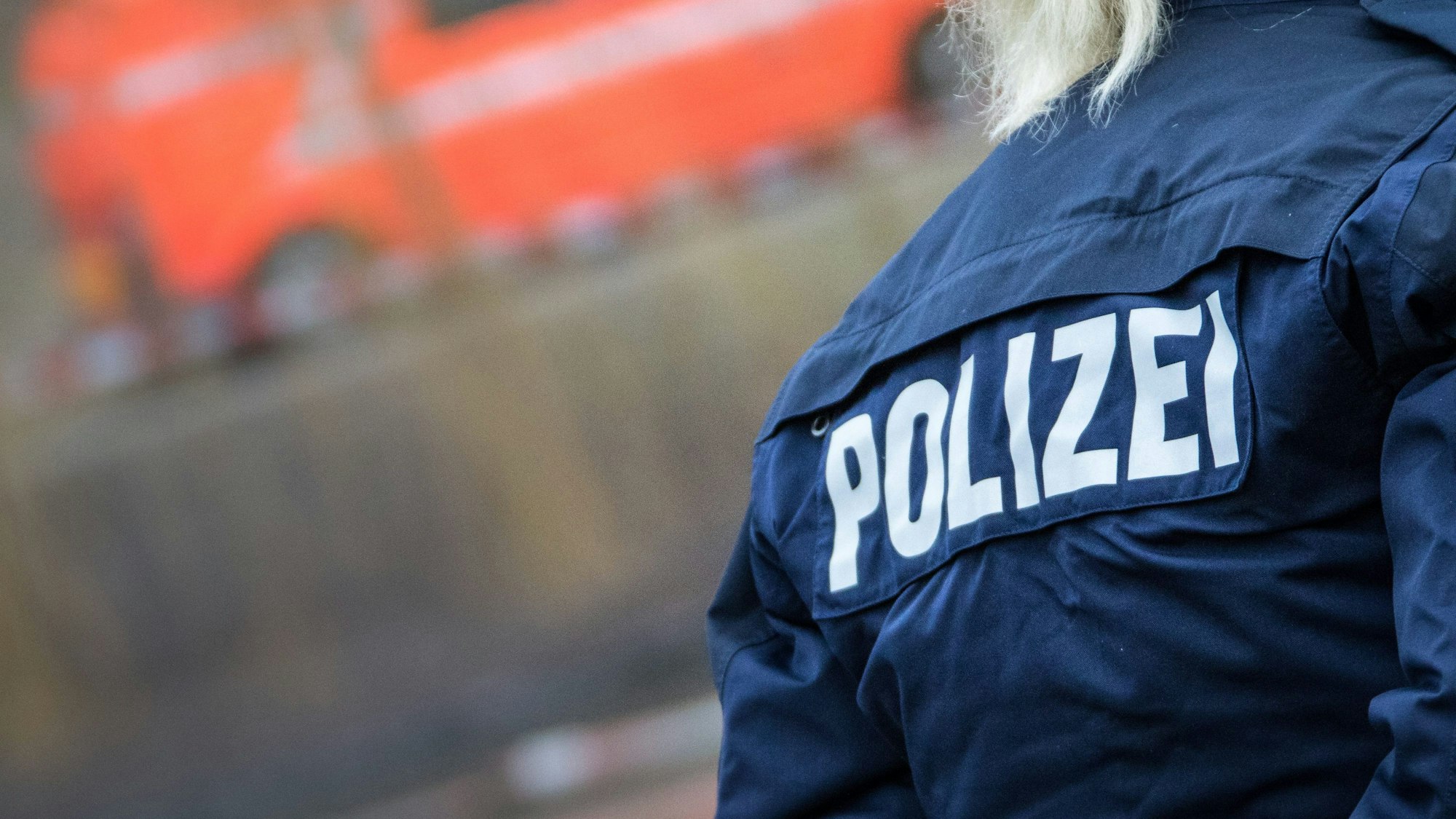 Eine Polizistin auf deren Jacke der Schriftzug "Polizei" zu sehen ist.