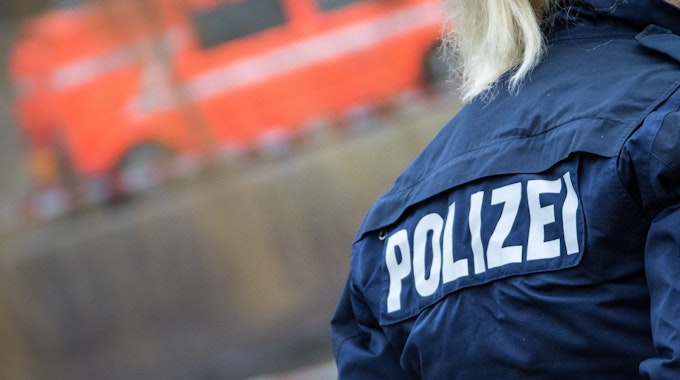 Eine Polizistin auf deren Jacke der Schriftzug "Polizei" zu sehen ist.&nbsp;