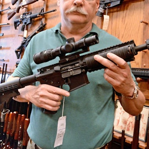 Ein Mann hält ein Sturmgewehr des Typs AR-15 in die Kamera.
