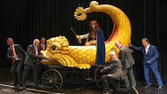 Übergabe des  historischen Festwagens an den „Held Carneval“ (Stefan F. Robert). Sechs Männer stehen um einen kleineren Karnevalswagen herum. Auf dem Wagen sitzt der „Held Carneval“ auf einem gelben Wasser-Fabelwesen.


