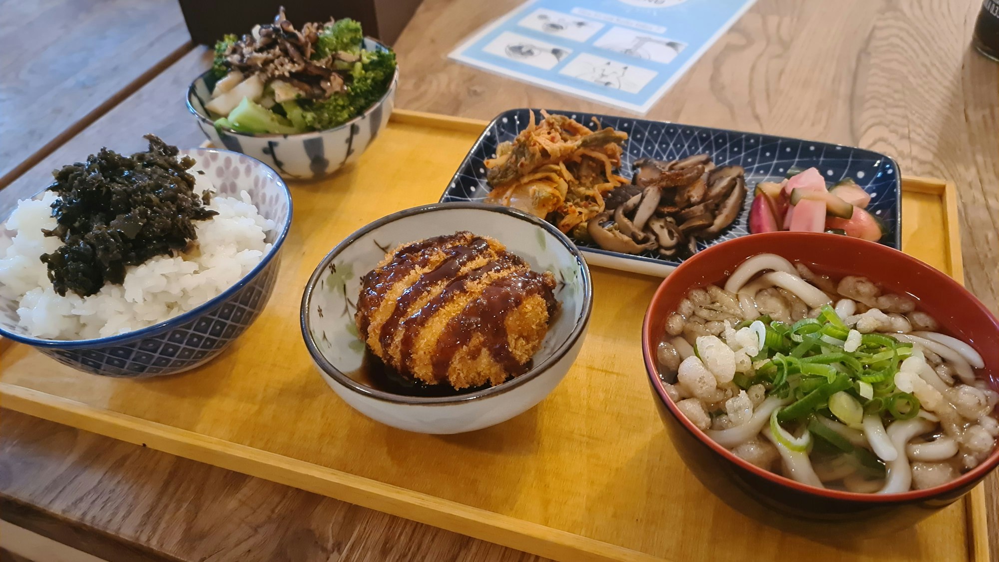 Verschiedene japanische Nudel- und Reisgerichte stehen auf einem Holzbrett