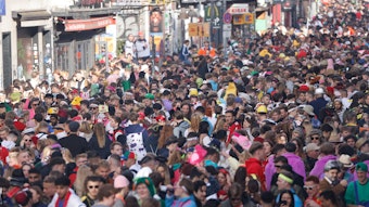 Menschen stehen verkleidet auf der Zülpicher Straße am 11.11.2022