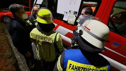 Bombenentschärfung in Bad Honnef. Feuerwehr steht vor Einsatzfahrzeug und bespricht sich.