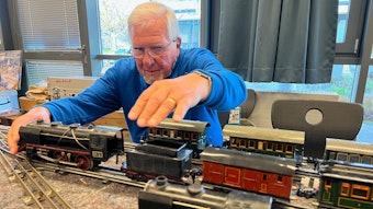 Der 80 Jahre alte Michael Rüttgers vom Eisenbahn Amateur Club setzt eine 87 Jahre alte Märklin-Lok vor einem Kohlentender auf die alten Gleise mit Mittelleiter.