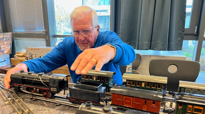 Der 80 Jahre alte Michael Rüttgers vom Eisenbahn Amateur Club setzt eine 87 Jahre alte Märklin-Lok vor einem Kohlentender auf die alten Gleise mit Mittelleiter.