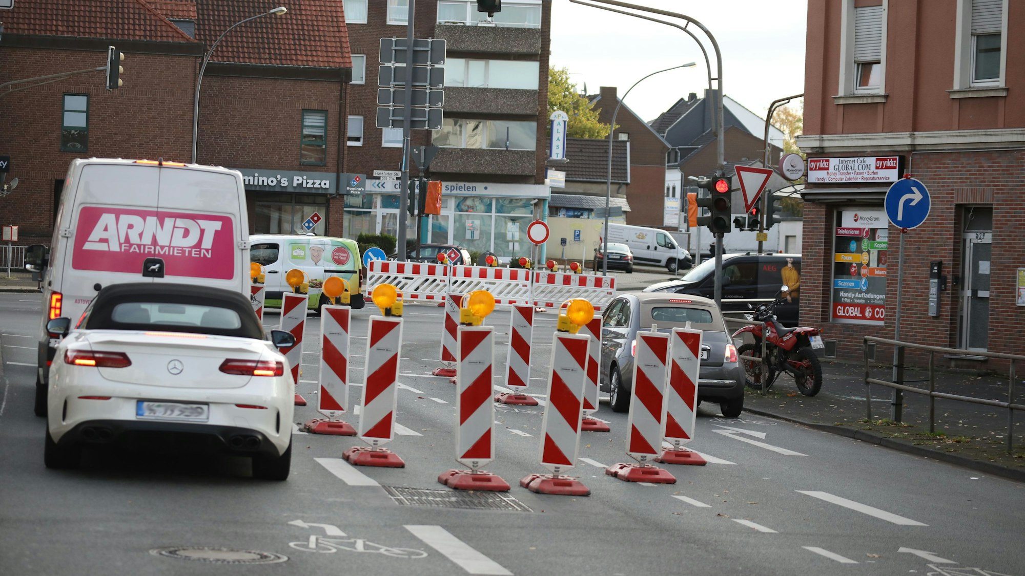 Die Einfahrt in die Kölner Waldstraße ist von der großen Kreuzung in Urbach (Frankfurter Straße/Kaiserstraße/Waldstraße) für mehrere Monate nicht möglich. Der Energieversorger Rheinenergie erneuert Stromkabel. Drei Autos stehen an einer roten Ampel. Auf dem mittleren der drei Fahrstreifen ist eine Baustelle.