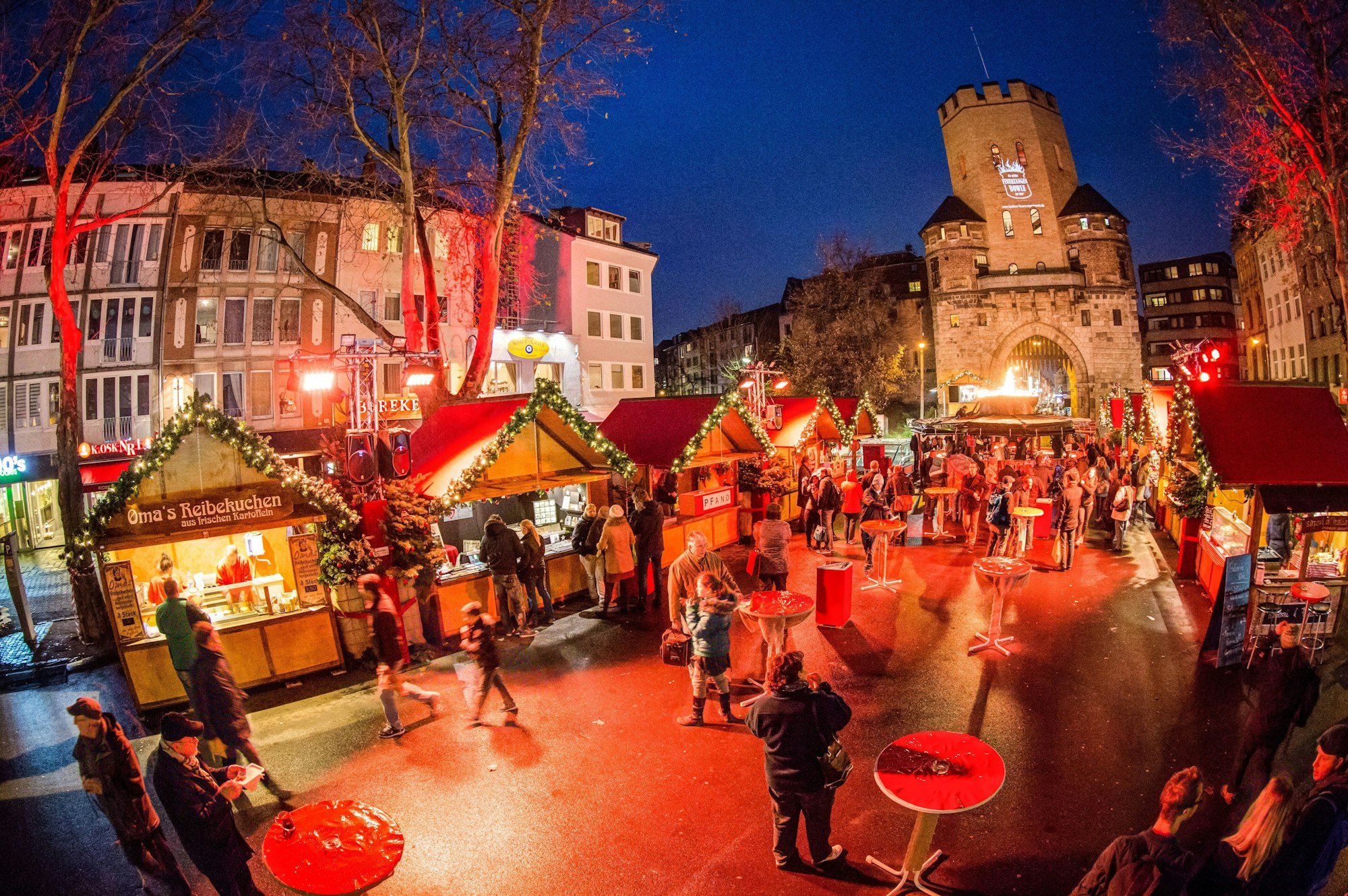 Weihnachtsmarkt auf dem Chlodwigplatz mit Severinstorburg im Hintergrund.