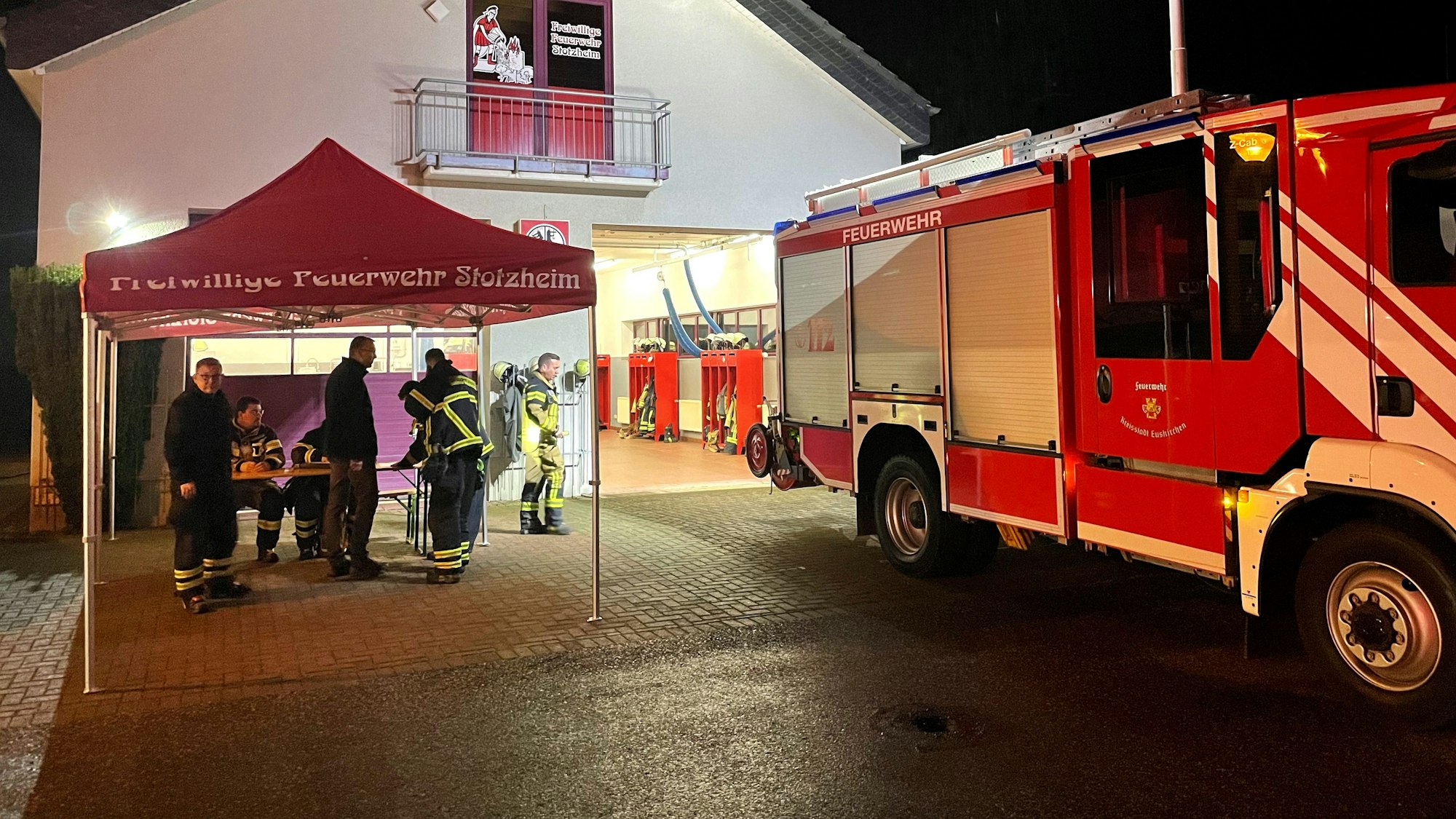Die Löschgruppe Stotzheim hat ein Zelt aufgebaut, in dem ein Schichtplan ausgearbeitet wird. Ein Feuerwehrauto steht vor dem Gerätehaus.