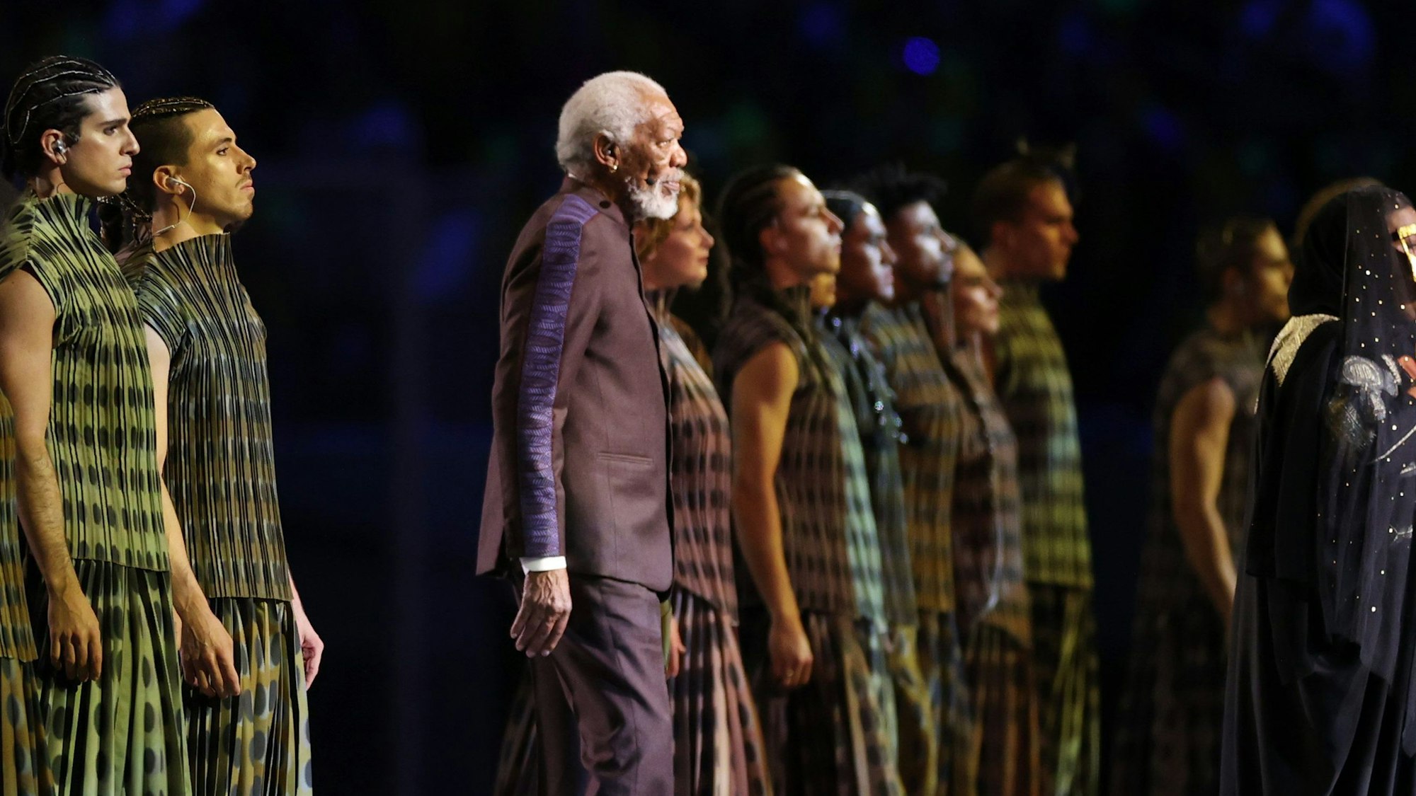 Morgan Freeman und zahlreiche Tänzer auf der Bühne in Katar.