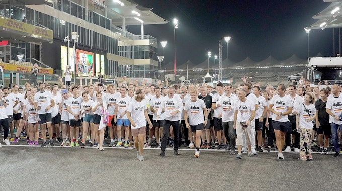 Sebastian Vettel sowie zahlreiche Kollegen und Freunde an der Ziellinie auf der Strecke in Abu Dhabi.