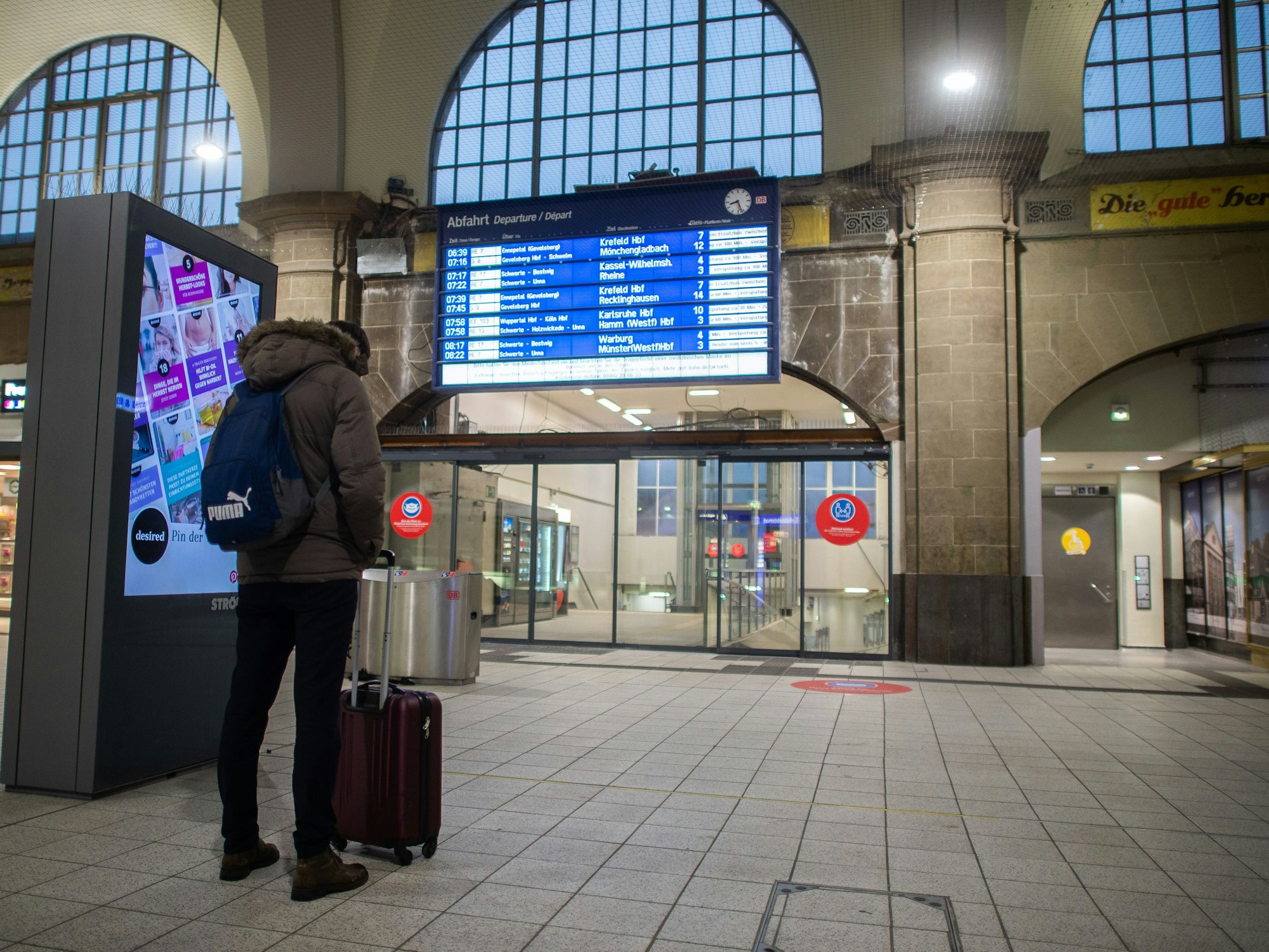 Ein Mann steht im Hagener Hauptbahnhof vor der Anzeigetafel.