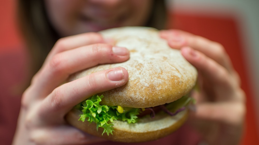 Das Foto, auf dem eine Frau einen Burger in den Händen hält, wurde im Februar 2016 in München aufgenommen und dient hier als Symbolfoto.